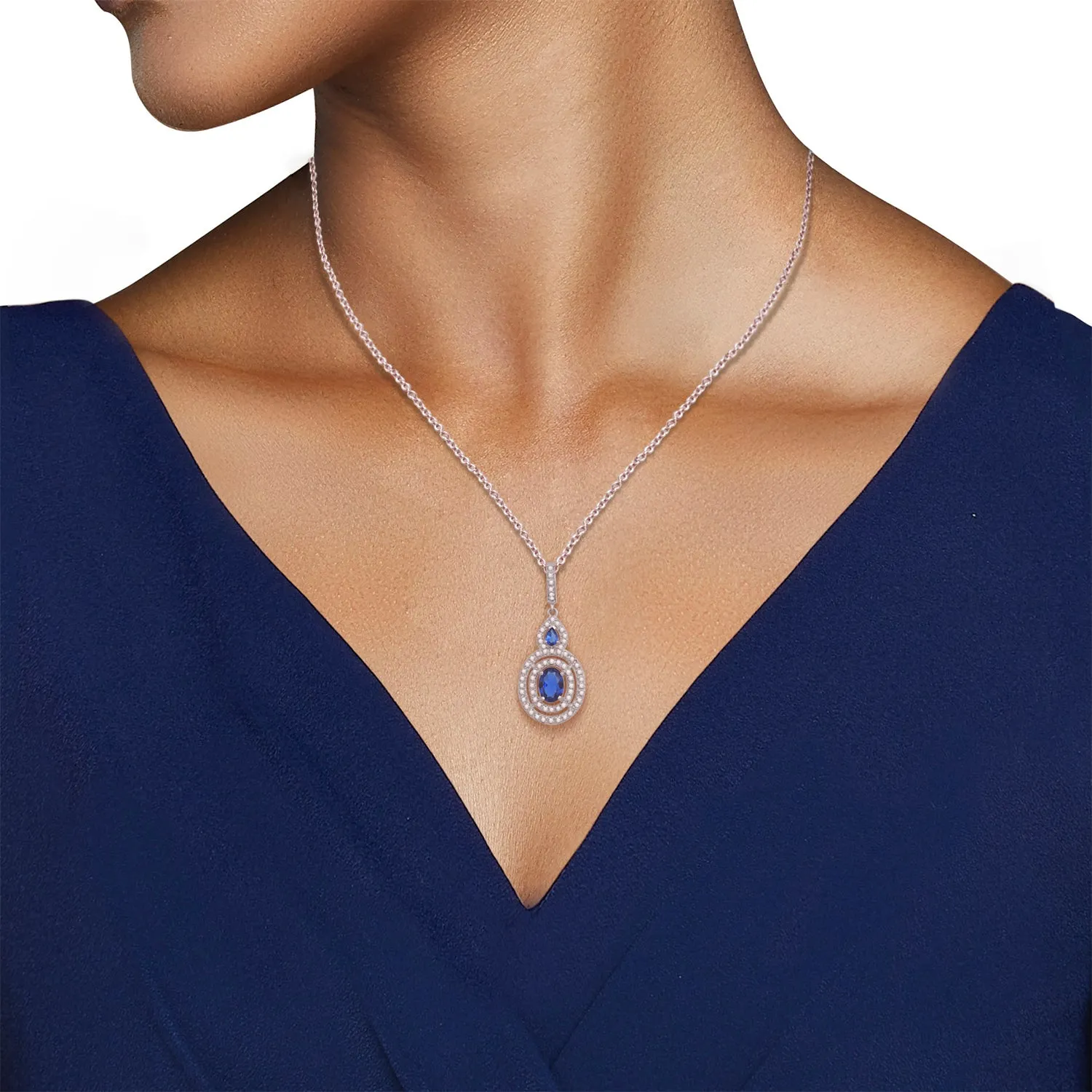 Jewelili Sterling Silver 6x8mm Oval Created Ceylon Sapphire, 3x4mm Pear Created Ceylon Sapphire and Round Created White Sapphire Halo Pendant Necklace, 18" Rolo Chain